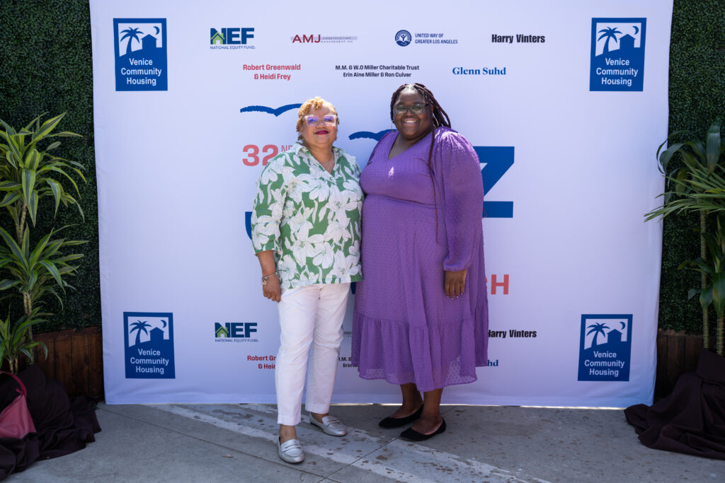 Two women in front of step-and-repeat backdrop at Jazz Brunch